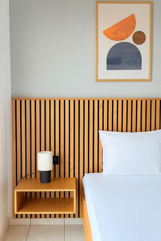 a bedroom with a bed and a table with a lamp at Harmonia Himara in Himare