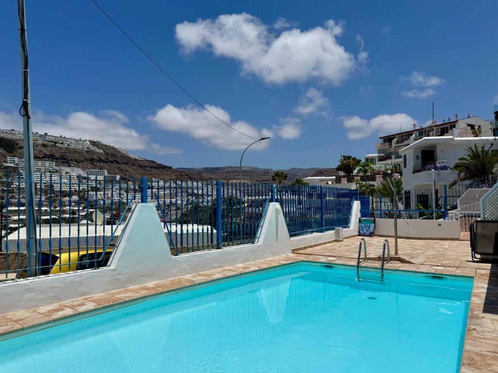 a swimming pool with a slide in front of a building at La Romana Apartment in Puerto Rico de Gran Canaria