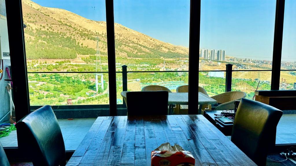 a table with chairs and a view of a mountain at Daik City Chaviland Fully Furnished Apartment in As Sulaymānīyah