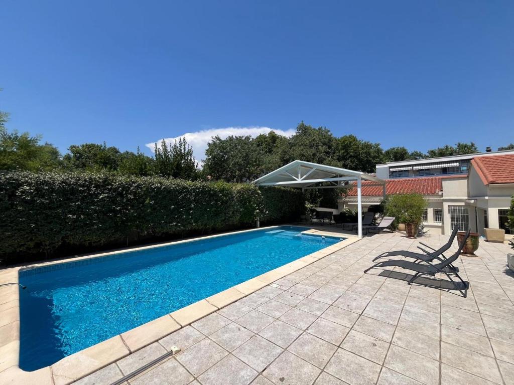 une piscine dans l'arrière-cour d'une maison dans l'établissement Maison de villa avec piscine privée à deux pas de centre de Montpellier, à Montpellier