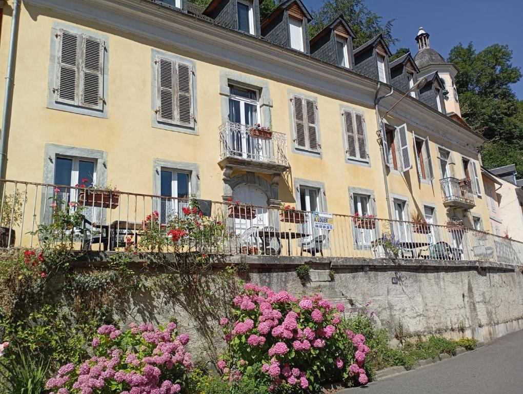 un bâtiment avec des fleurs devant lui dans l'établissement STUDIO 2 LUZ SAINT SAUVEUR 4 Personnes, à Luz-Saint-Sauveur