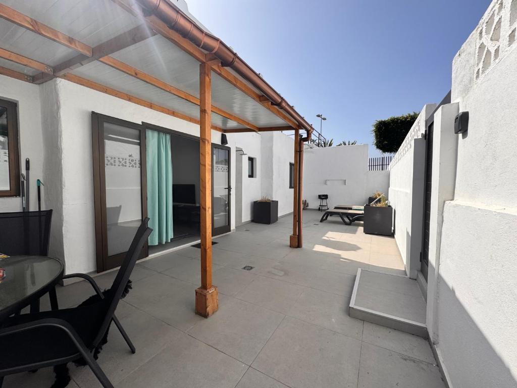 een patio met een luifel, een tafel en stoelen bij Yumbo Rainbow Homes A in Maspalomas