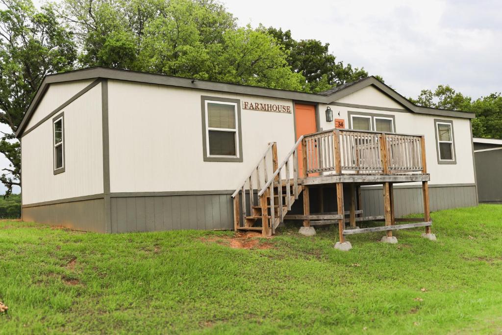 a tiny house with a porch and a deck at Lakefront Farm House - 34 in Mead