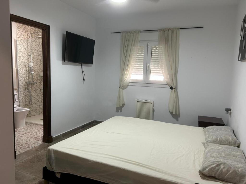 a bedroom with a bed and a window and a television at Casita Bella in Chiclana de la Frontera