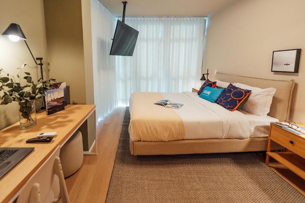 a hotel room with a bed and a desk with a desk at Fuji by Xtay - Estúdios completos no Centro, ao lado do Museu Histórico e mercado local in Florianópolis