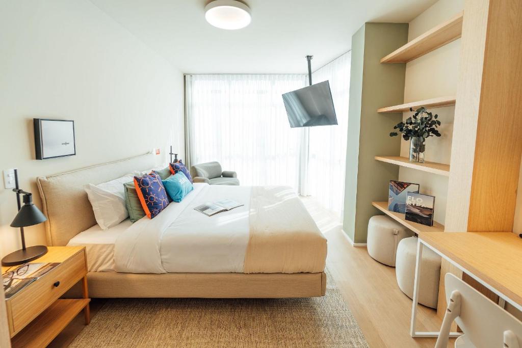 a bedroom with a large bed and a window at Fuji By Xtay Florianópolis - Hospede-se a minutos do centro de eventos no CentroSul in Florianópolis