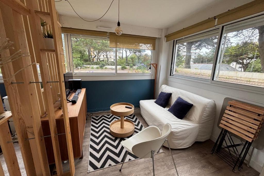 - un petit salon avec un canapé blanc et une table dans l'établissement Charming T1 on the seafront, à La Baule