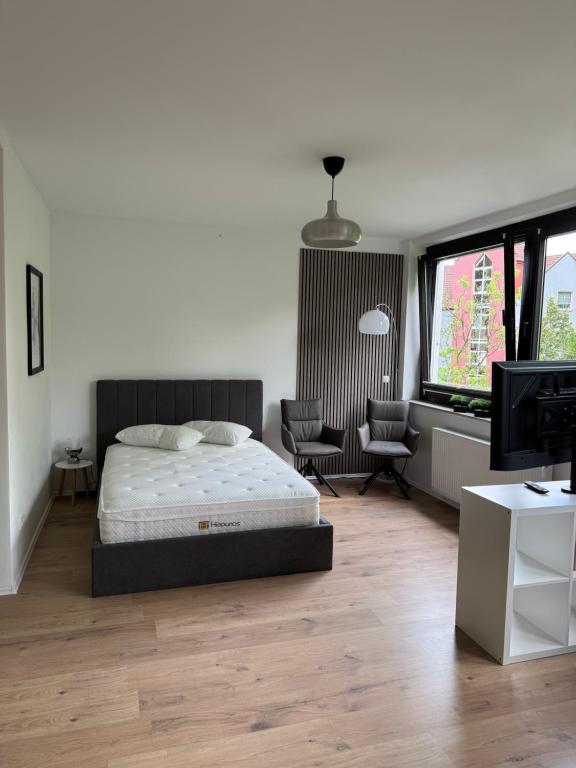 a bedroom with a bed and a desk and a chair at Deluxe Apartment in Kaisernähe in Porta Westfalica
