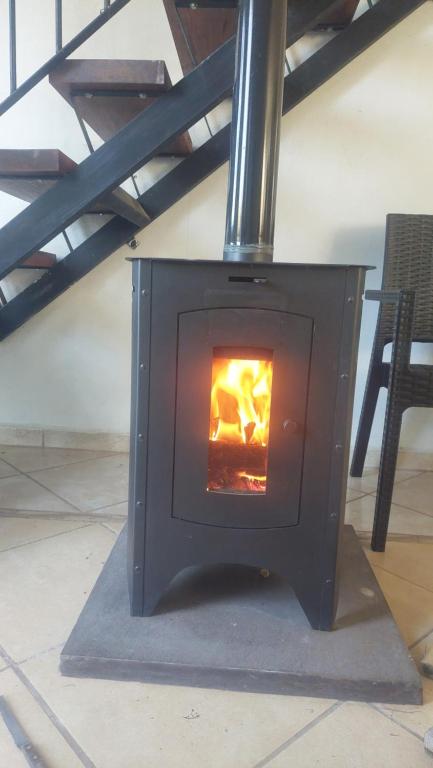 a black stove with a fire inside of it at Los Horneros in Potrero de Garay