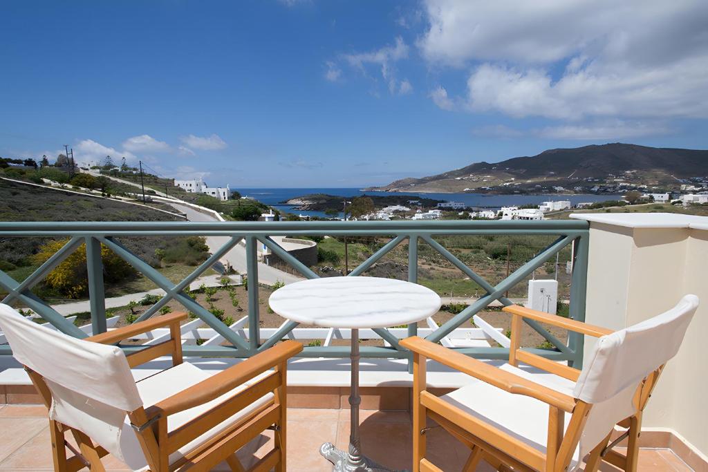 Un balcón con mesa y sillas y el mar. en Sunset Retreat Villa Sophia, en Posidhonía