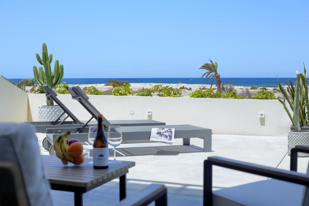 a table with a bottle of wine and fruit on a patio at Kokomo beachfront in Cotillo
