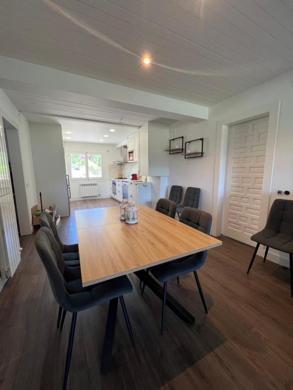 a dining room and kitchen with a wooden table and chairs at Maravilloso apartamento en Llívia in Llivia
