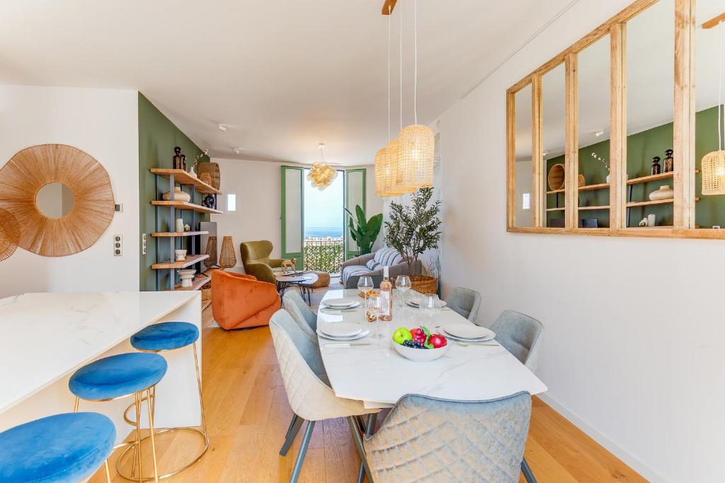a dining room and living room with a table and chairs at 33 MARINONI AP4438 by Riviera Holiday Homes in Beaulieu-sur-Mer