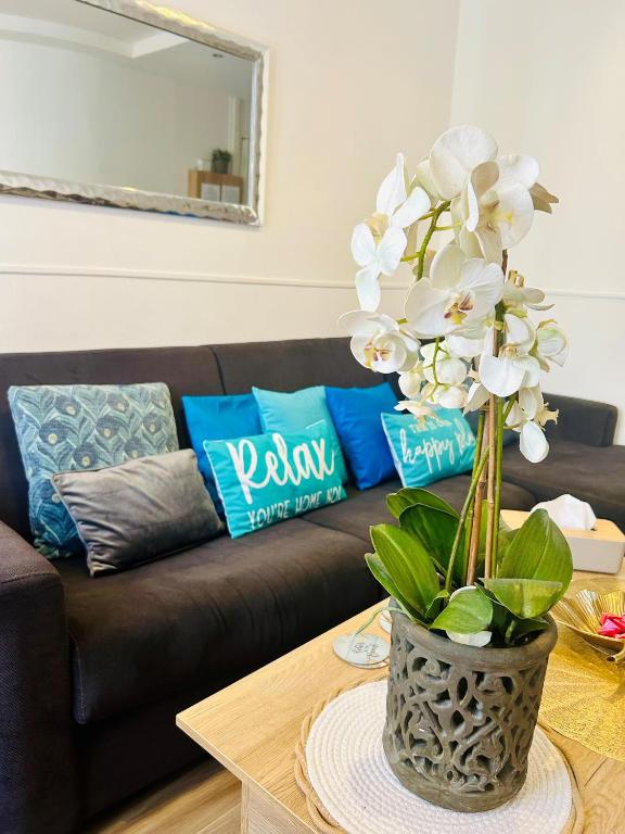- un salon doté d'un canapé et d'une table avec un vase fleuri dans l'établissement Casa Blue Azur - Juan Les Pins, à Antibes