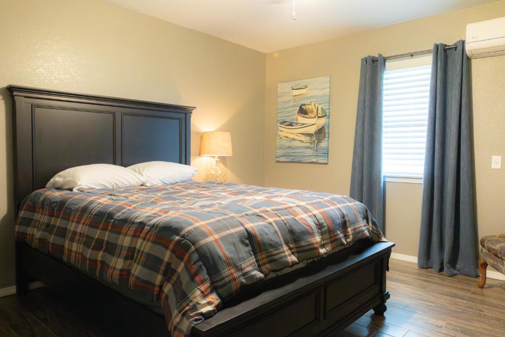 a bedroom with a bed with a plaid blanket and a window at Lakeview Room 2 Queens - 23 in Mead