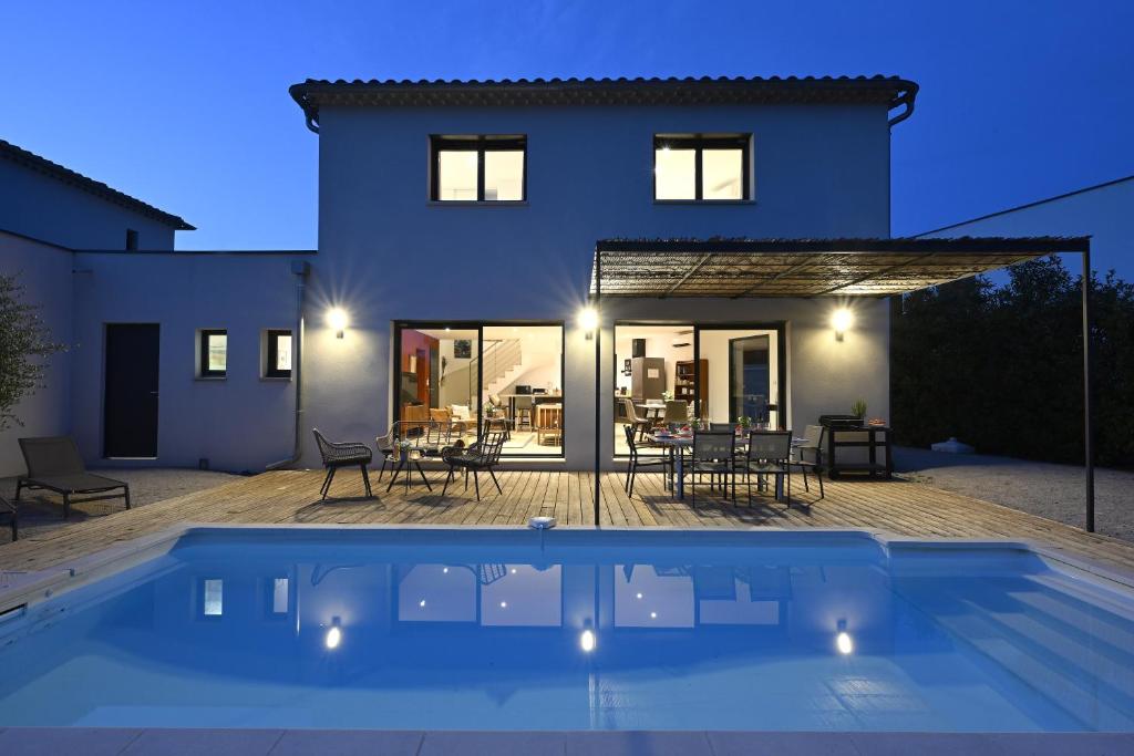 une maison avec une piscine devant une maison dans l'établissement La Villa Plein Soleil, à LʼIsle-sur-la-Sorgue