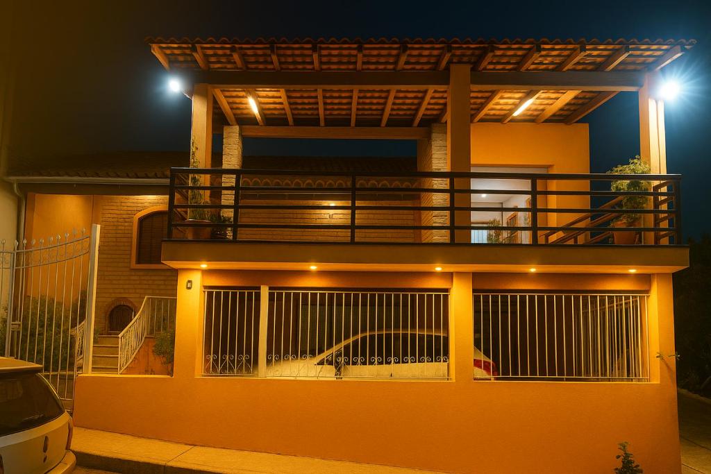 ein Haus mit einem Balkon und einem darunter geparkt in der Unterkunft Pousada Primavera in Cachoeira Paulista