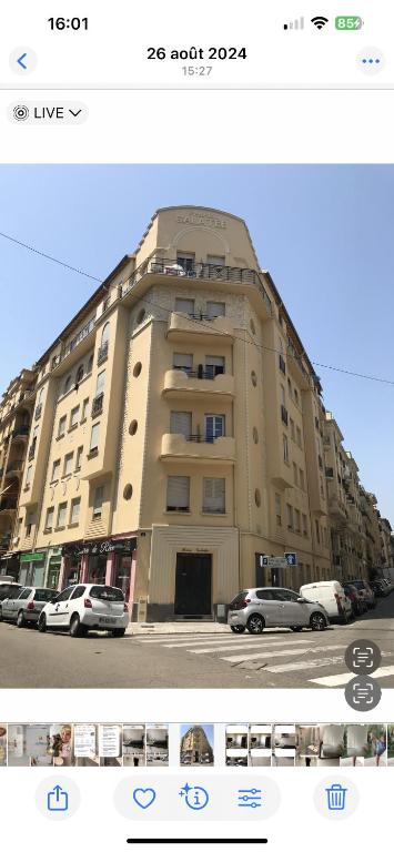 ein großes Gebäude, vor dem Autos parkten in der Unterkunft Studio centre ville in La Celle-sous-Gouzon
