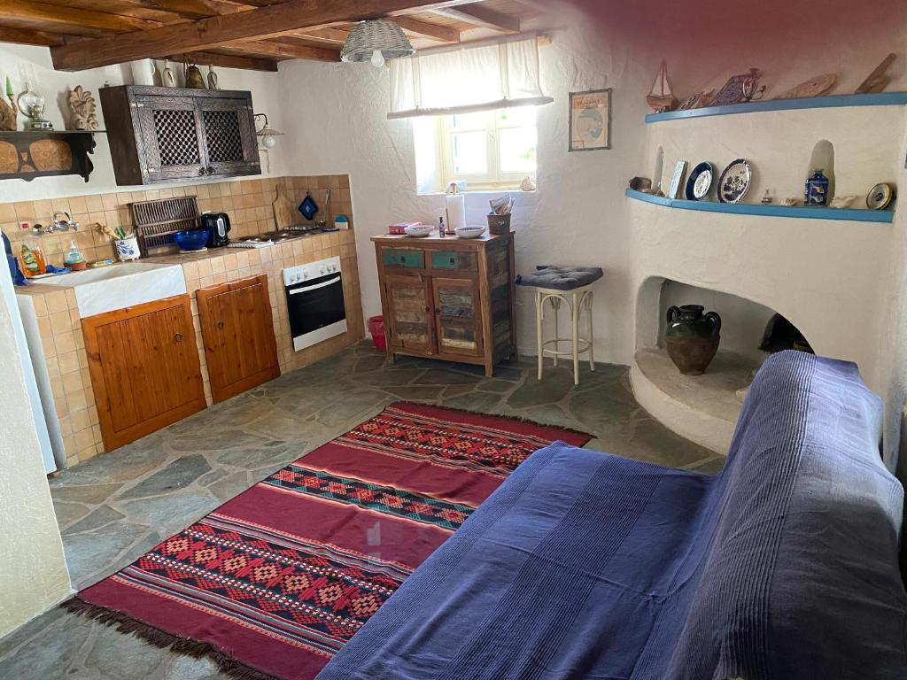 a living room with a kitchen with a fireplace at Two sisters in Alonnisos Old Town