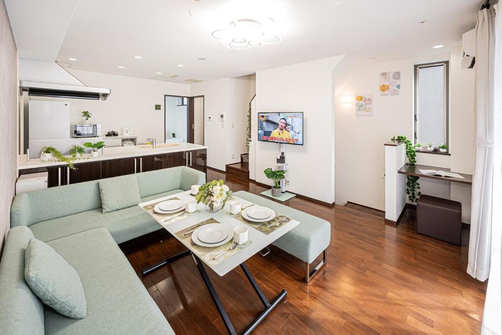un soggiorno con un divano e un tavolo di Fukuei Stay Premium a Tokyo