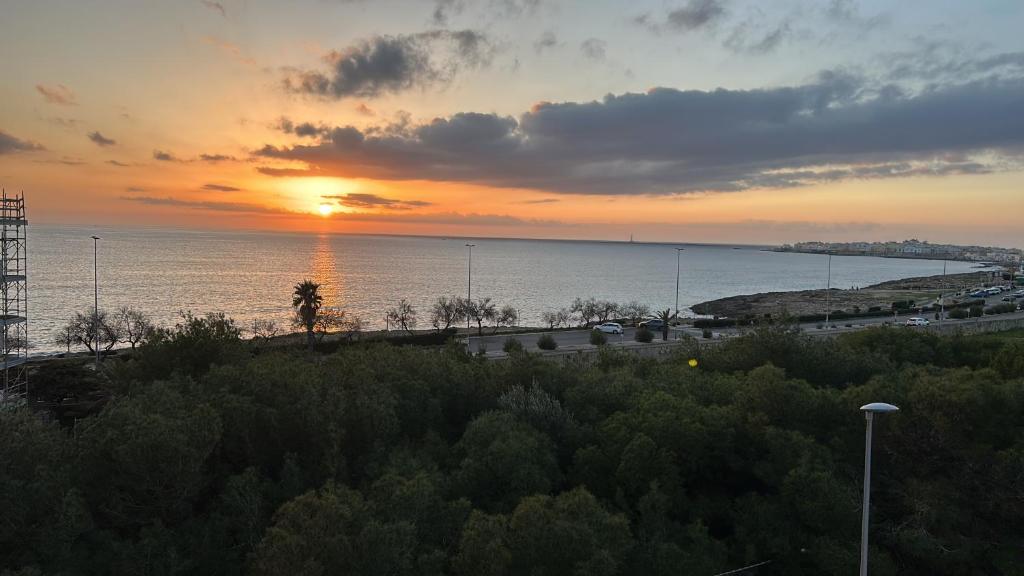 a sunset over a body of water with the sun setting at La Pilozza in Gallipoli
