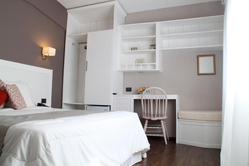 ein Schlafzimmer mit einem Bett, einem Schreibtisch und einem Stuhl in der Unterkunft Hotel Milano in Punta del Este