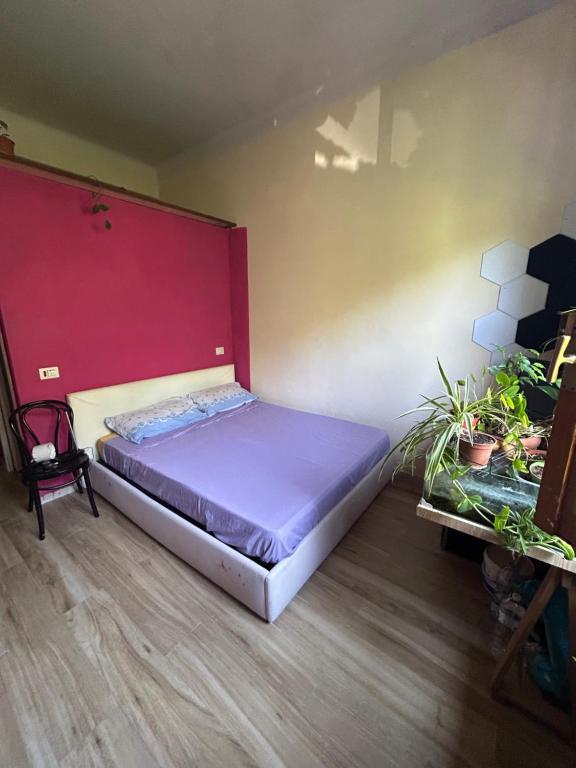 a bedroom with a bed with a red wall at San Siro rooms in Milan