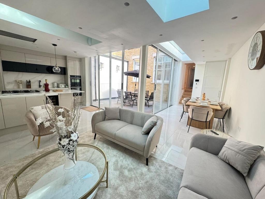 a living room with two couches and a table at The Grand Royal Kilburn House - 4BR/3BR w Parking in London