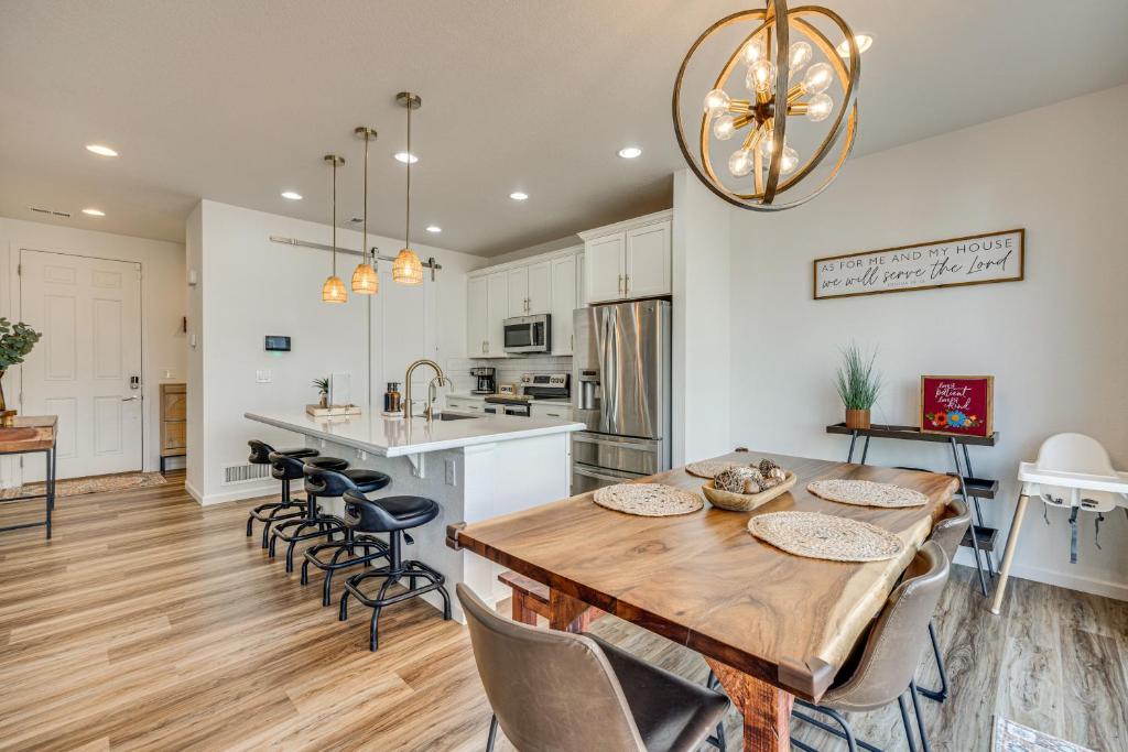 Una cocina y un comedor con mesa y sillas de madera. en Bright Colorado Springs Home, 10 Mi to Dtwn!, en Fountain
