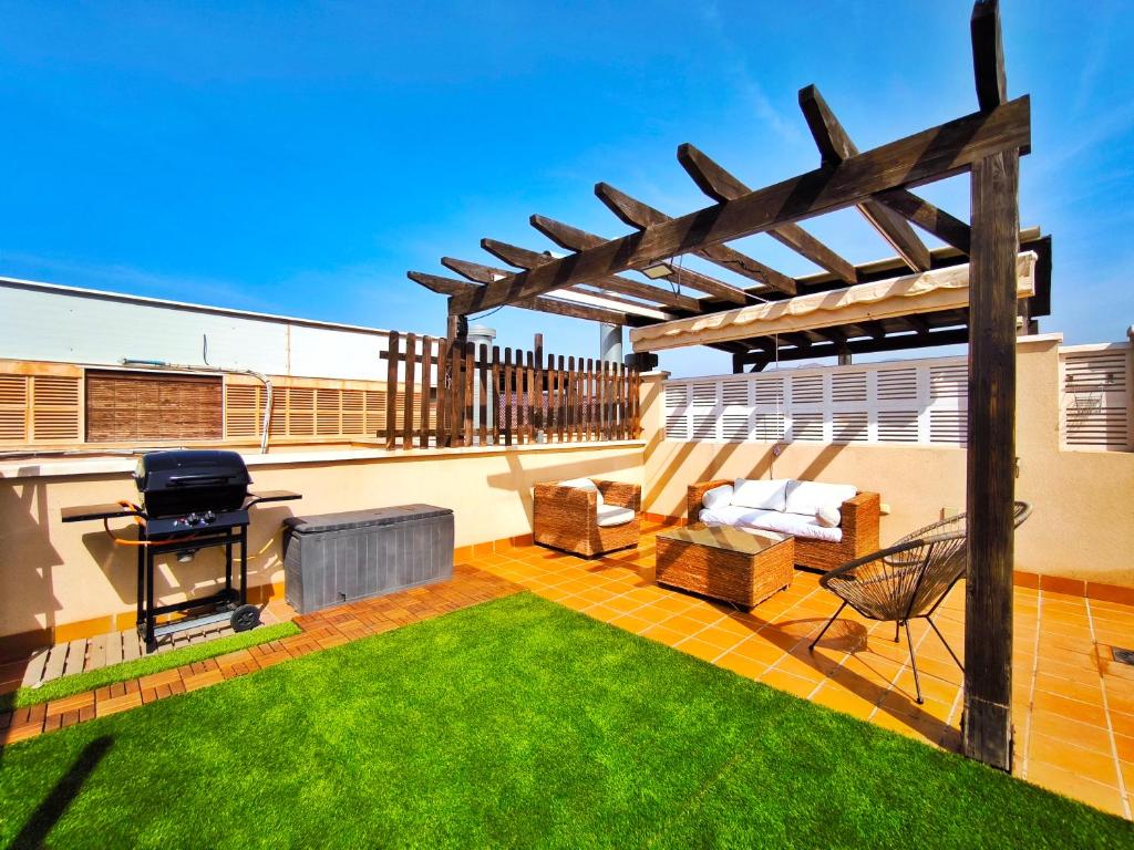 a patio with a grill and a barbecue on a roof at Ático con Terrazas y Piscina en Aguadulce in Roquetas de Mar