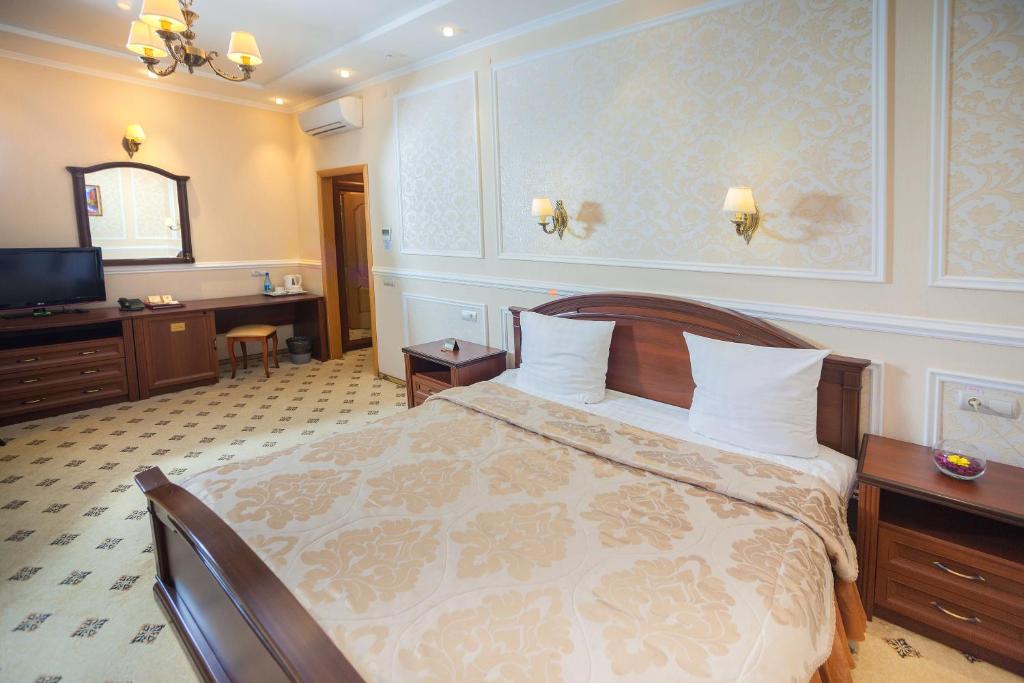 - une chambre avec un lit, un bureau et une télévision dans l'établissement Prestige, à Koursk