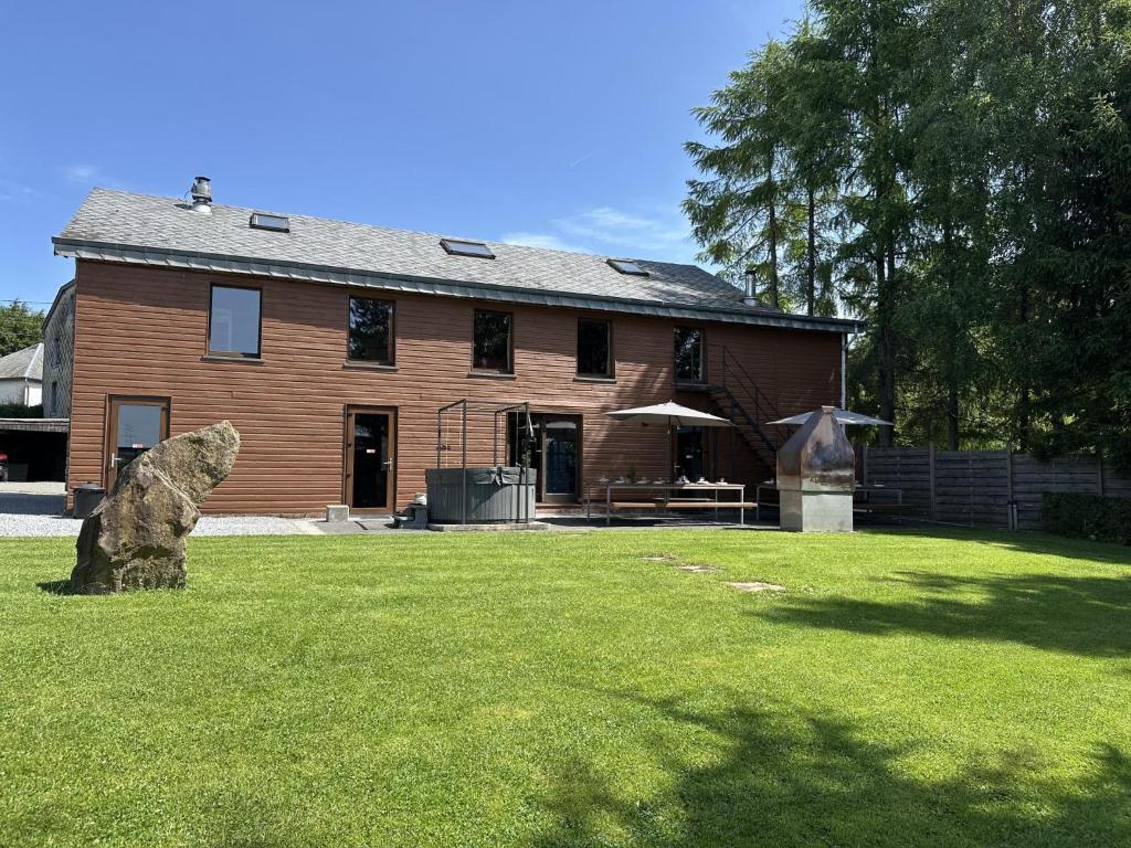 a house with a large rock in the yard at Langlire in Gouvy