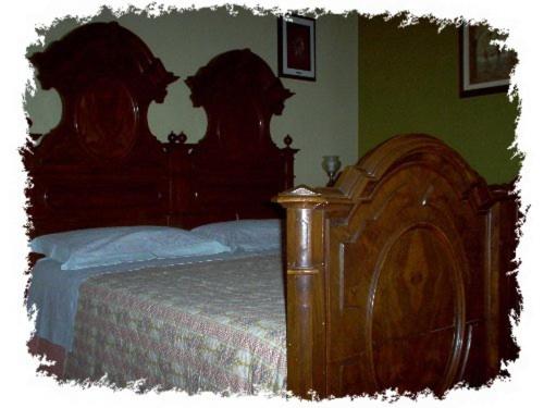 カストロカーロ・テルメにあるAgriturismo Monte Valbelleの木製ヘッドボード付きの木製ベッドが備わるベッドルーム1室が備わります。