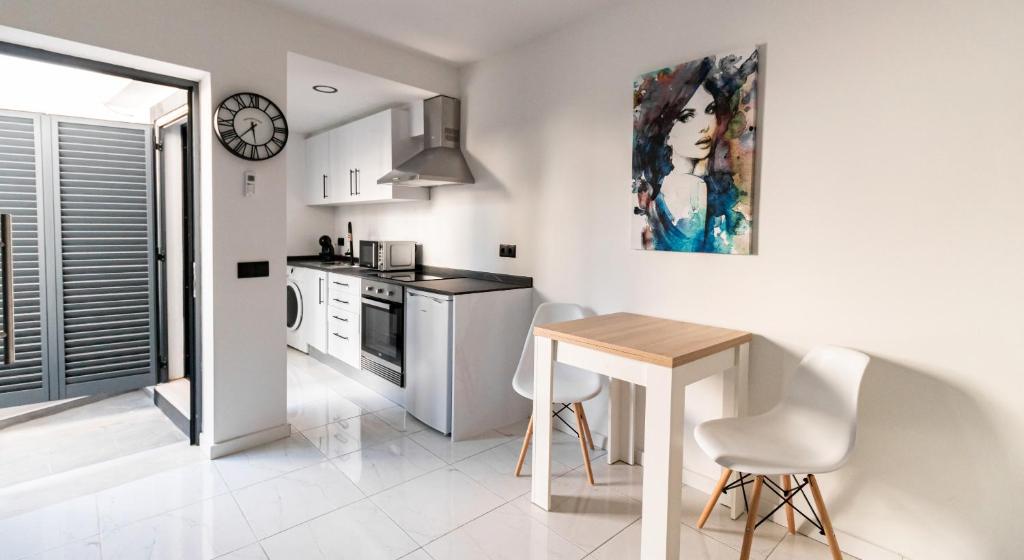 a kitchen with a table and chairs and a clock at Mi Casa Es Su Casa Nº1 in Albufeira