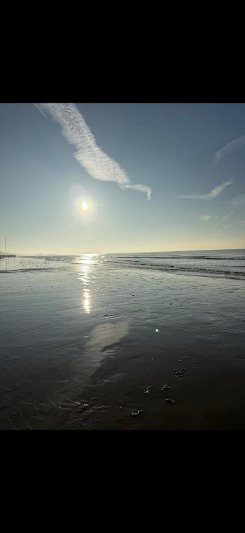 a beach with the sun reflecting on the water at Stylish seafront flat in Hove in Brighton & Hove