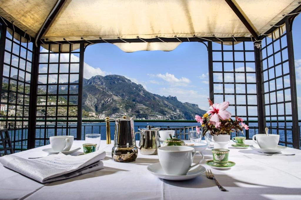 a table with a view of the water and mountains at onde di luce in Ravello