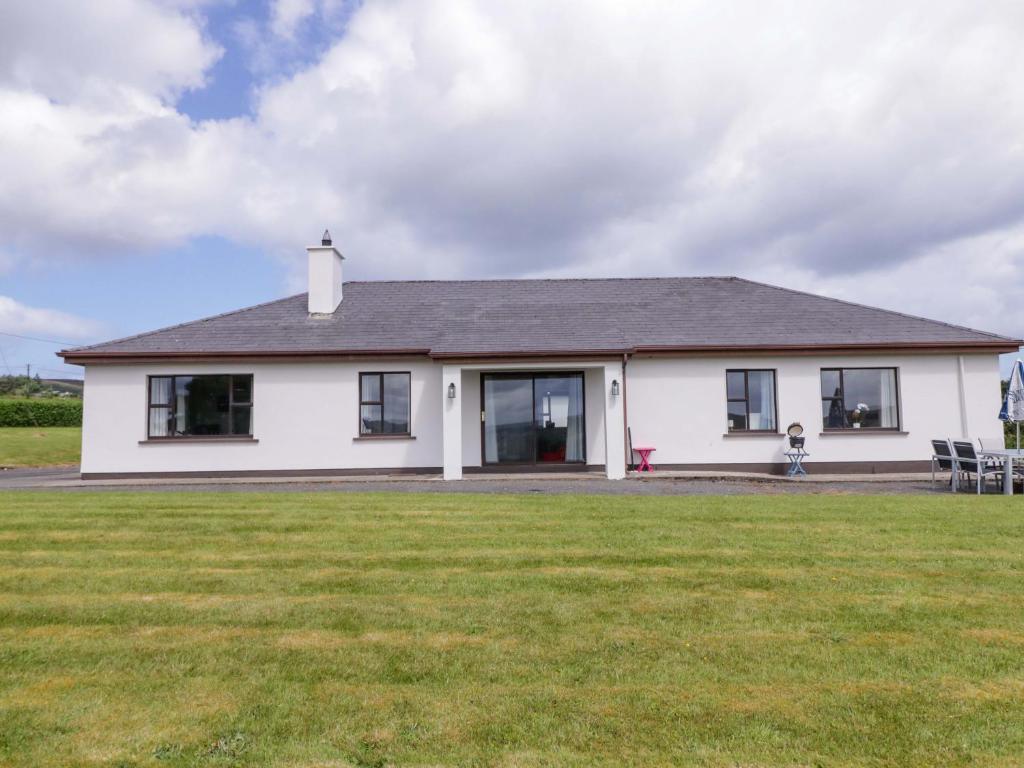 a white house with a lawn in front of it at Ard Na Mara in Culdaff