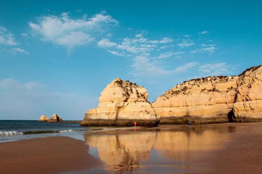 a beach with some rocks in the water at Casa do Rio - Apartment Earth in Portimão