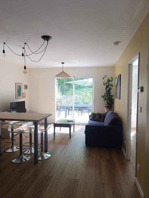 a living room with a couch and a table at Lisière Hébergements - Casa Mouette Mouette in La Tremblade