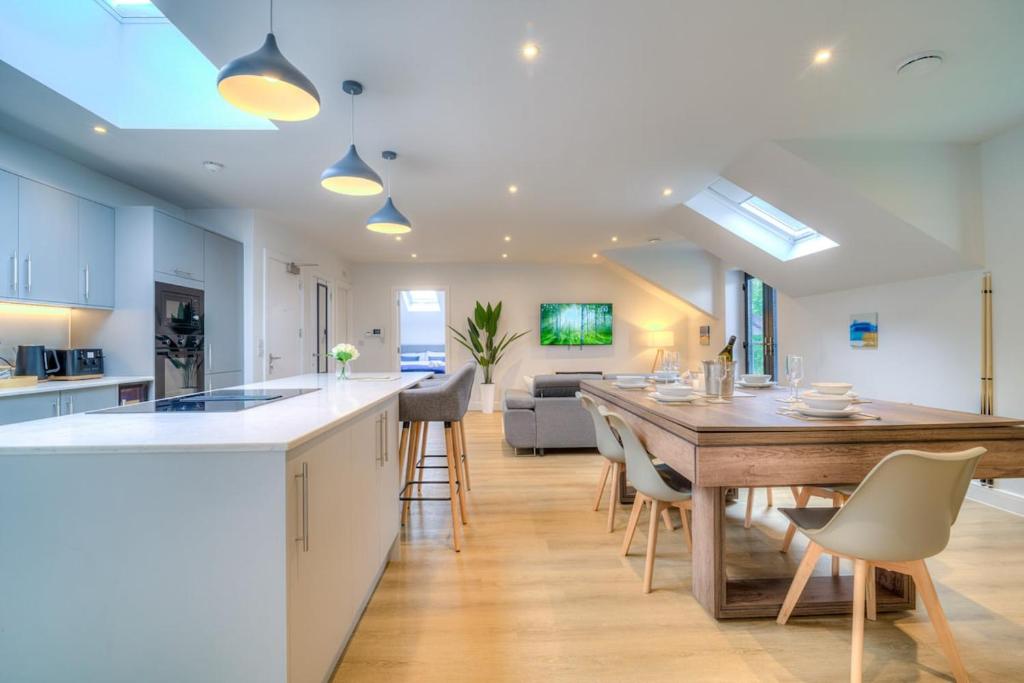 a kitchen and living room with a table and chairs at Luxury Penthouse Flat Manchester in Wythenshawe