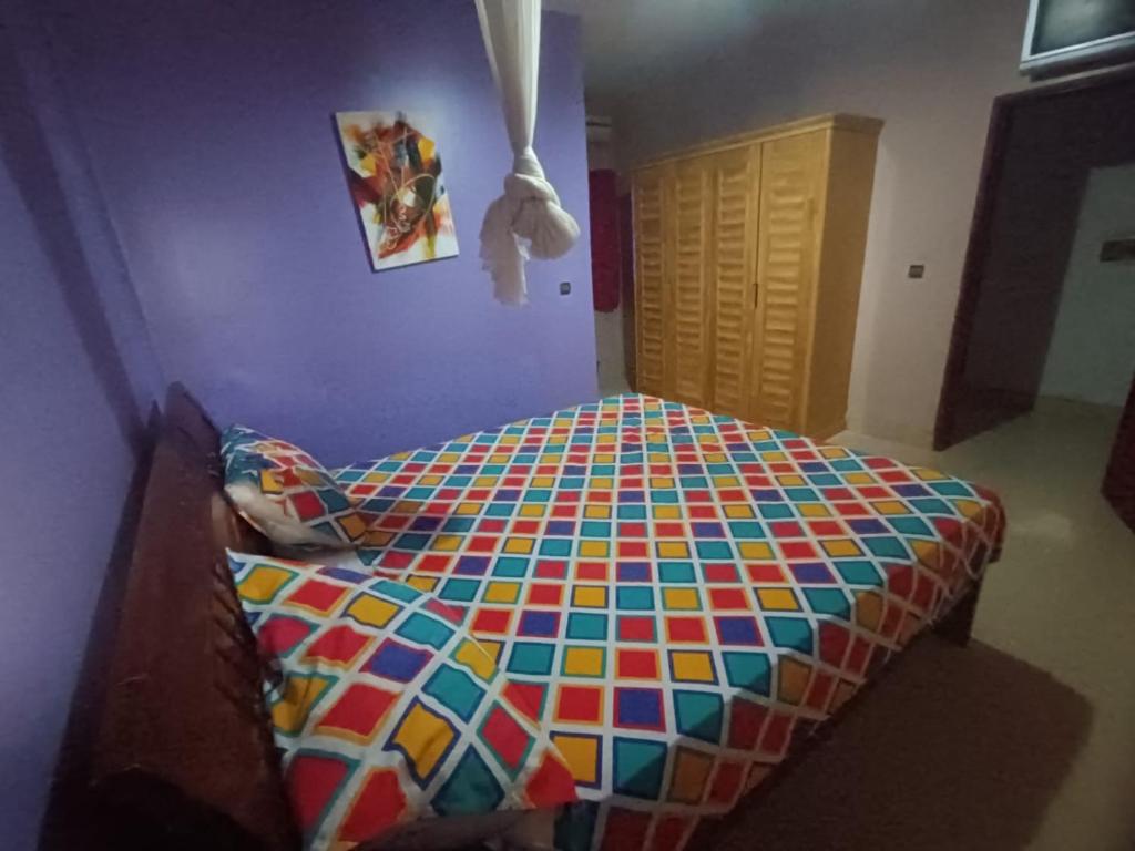 a bedroom with a colorful bed in a room at Blue House in Saly Portudal