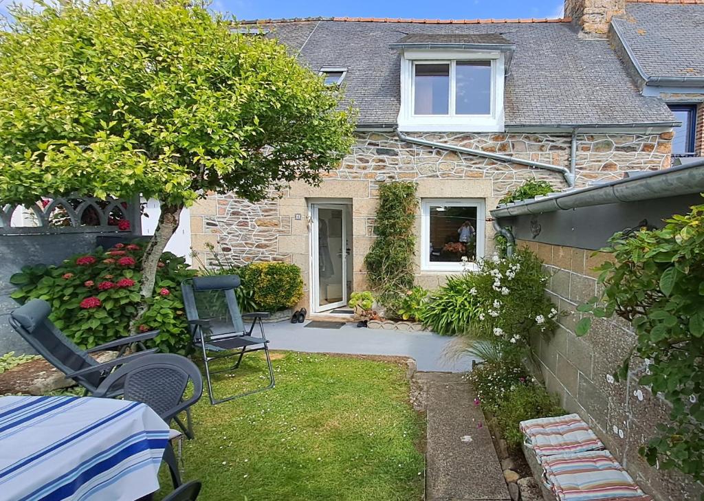 a small yard with chairs and a house at Chez Édouard et Aline classé 2 étoiles in Ploubazlanec