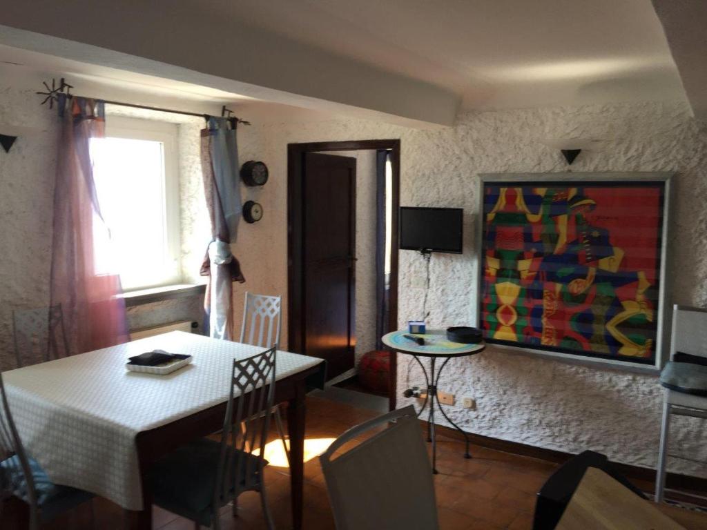 una sala de estar con una mesa y una pintura en la pared en My Holiday La Serra, en Lerici