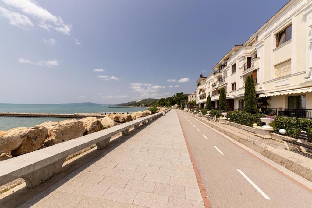 an empty street next to the water with buildings at La Veranda Apartment, complex Carpe Diem, Free Parking & Swimignpool in Balchik