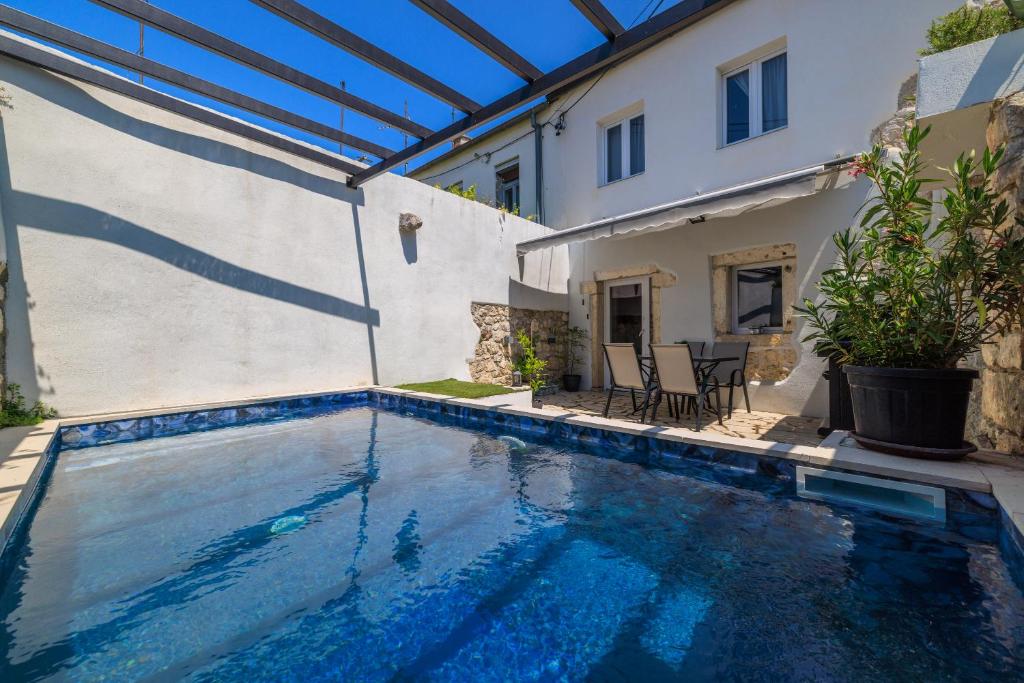 een zwembad met een pergola naast een huis bij Stone House ZEN in Grižane