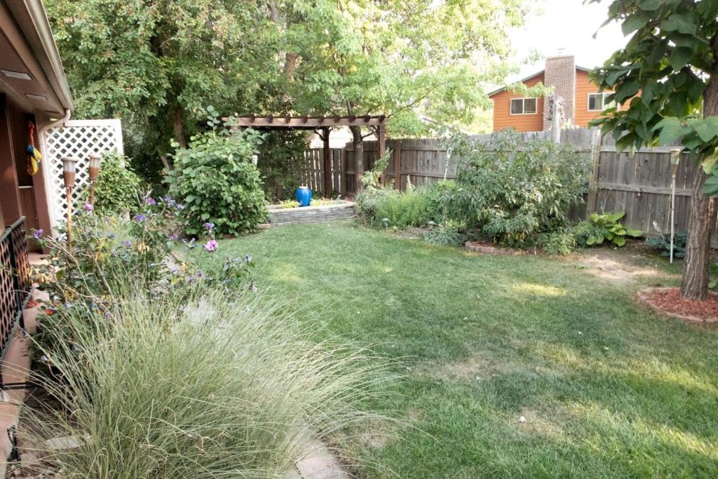 un cortile con recinzione e un cortile con prato di Sunny Family Retreat HotTub, GameRoom, Backyard a Longmont