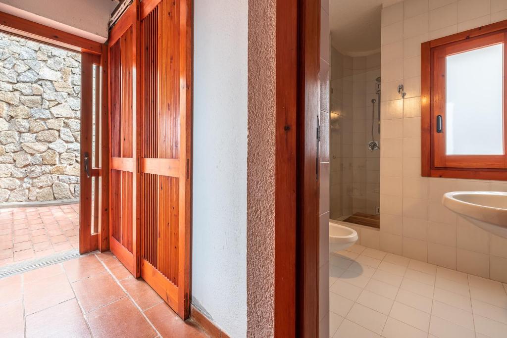 une salle de bain avec des toilettes, un lavabo et une porte dans l'établissement Pedra - Seaside & pool villa in wild Mediterranean, à San Stèfano 34 autres photos