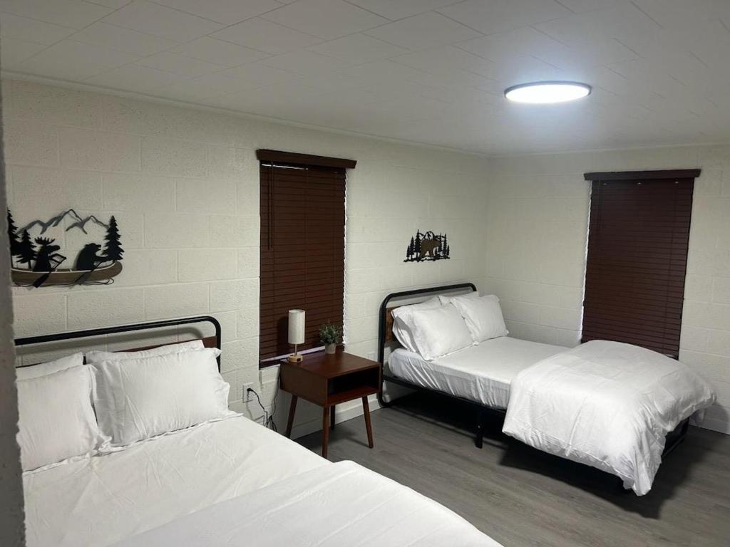 een slaapkamer met twee bedden en een tafel met een nachtkastje bij Cookson Resort - Tenkiller Cabin 2 in Cookson