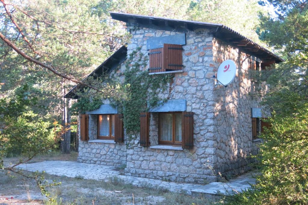una casa de piedra en medio de un bosque en La Caseta del Port, en Alfara de Carles