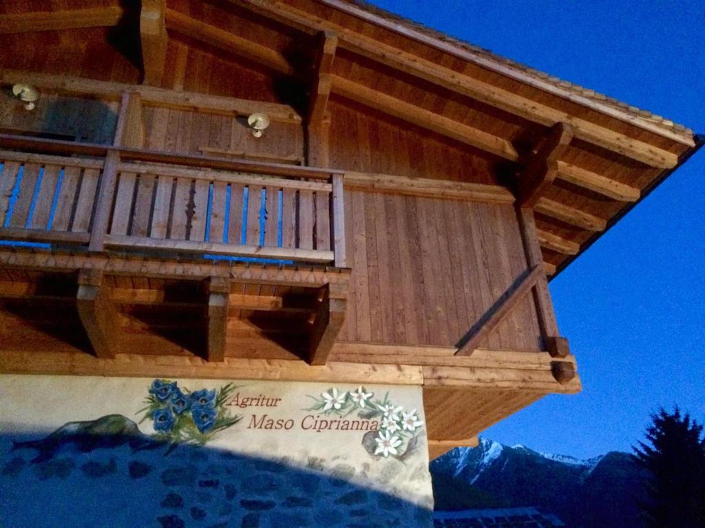 a large wooden balcony on a house with a mountain at Agritur Maso Ciprianna B&B in Rabbi